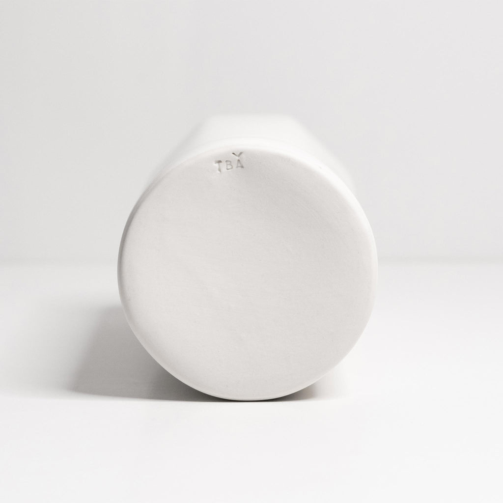 Ember Collective Bloom Vase, handmade white porcelain with a subtle oval rim, 8 inches tall, holding a small floral arrangement
