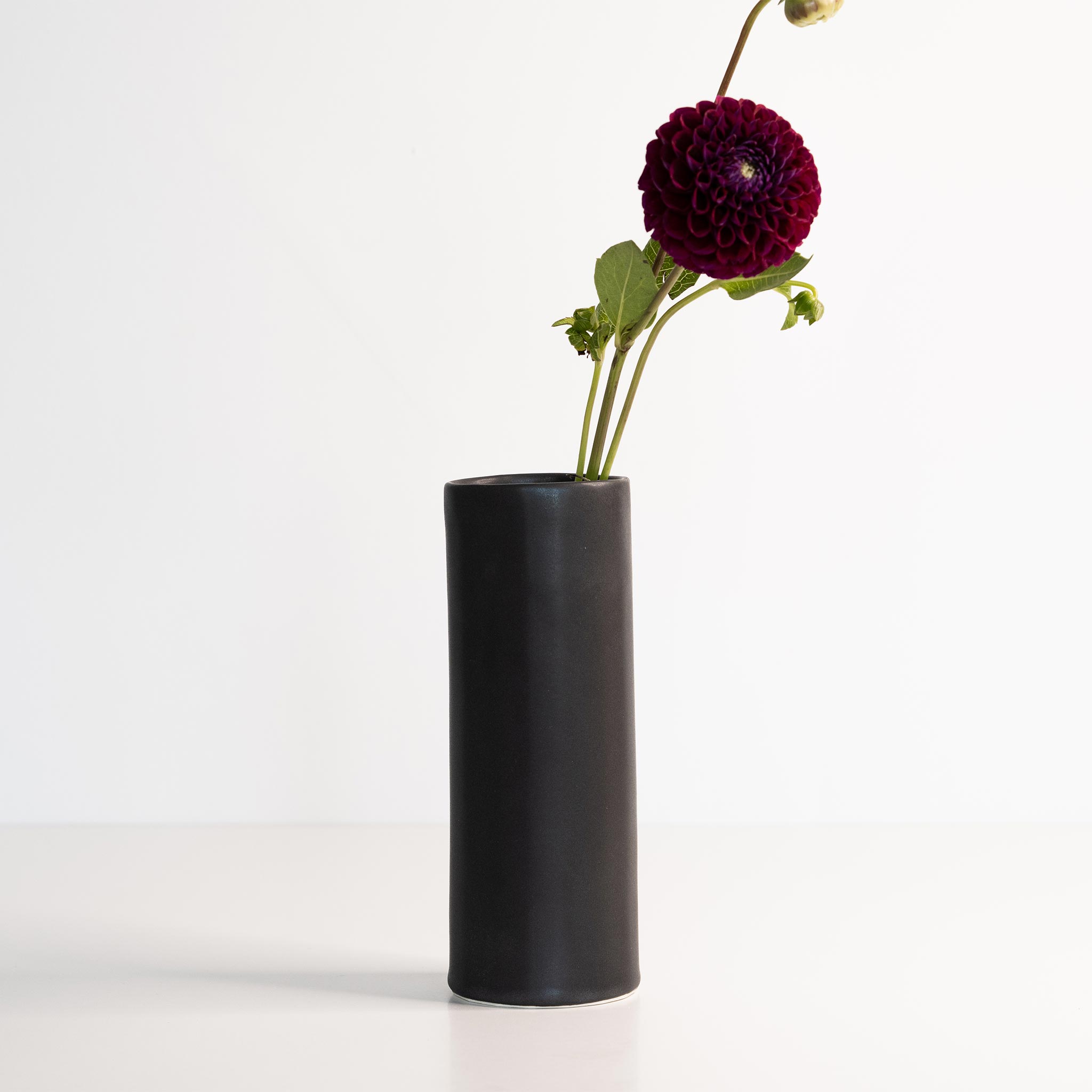Ember Collective Bloom Vase, handmade white porcelain with a subtle oval rim, 8 inches tall, holding a small floral arrangement