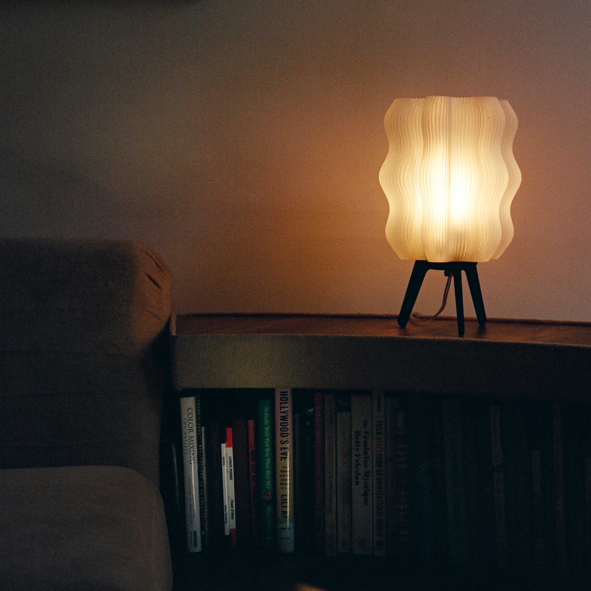 Wavy sculptural table lamp in recycled corn-based plastic with organic rippled silhouette on a flat surface