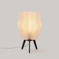 Wavy sculptural table lamp in recycled corn-based plastic with organic rippled silhouette on a flat surface