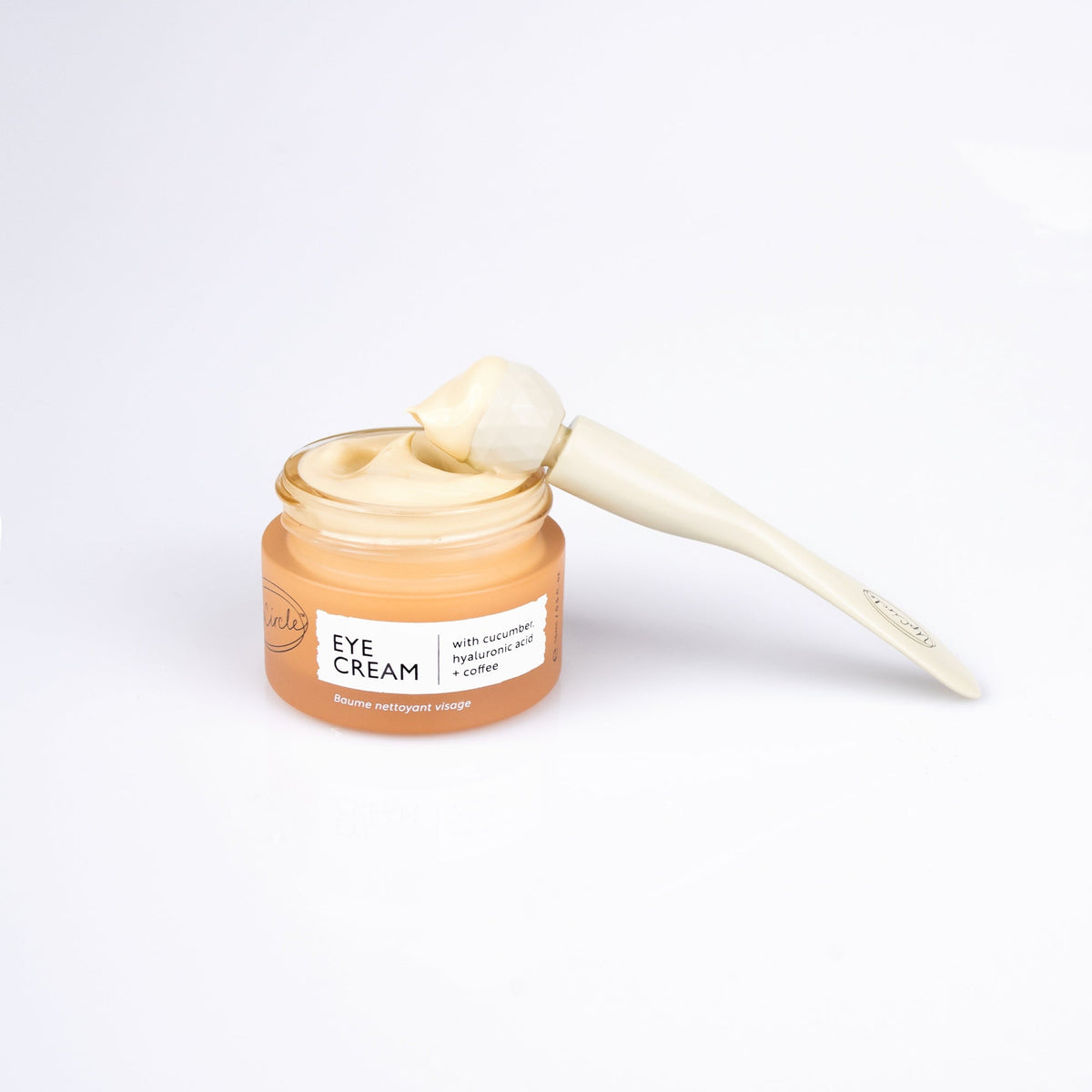 UpCircle eye cream in a glass jar with aluminium lid, showing coffee oil and hyaluronic acid formula for dark circles
