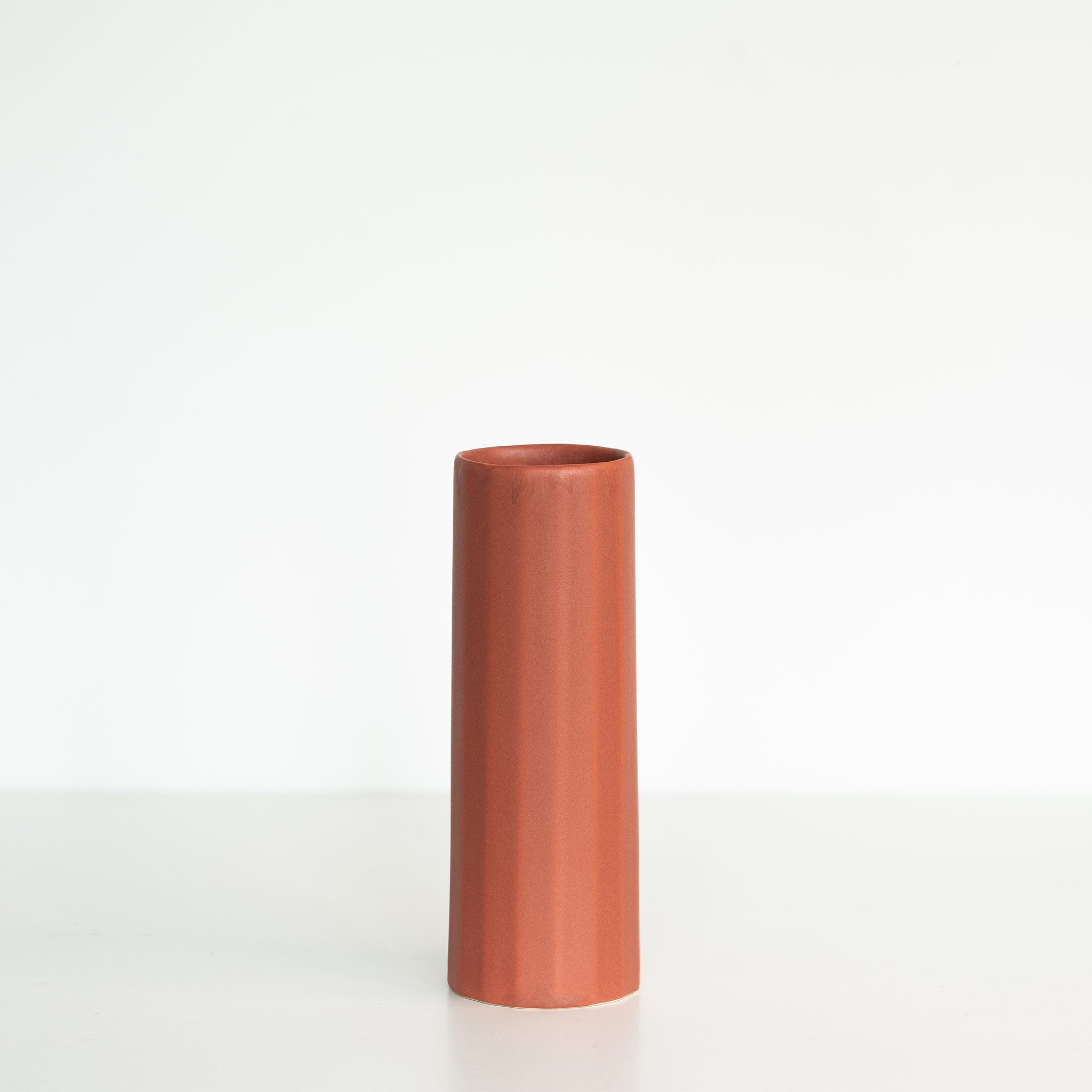 Ember Collective Bloom Vase, handmade white porcelain with a subtle oval rim, 8 inches tall, holding a small floral arrangement