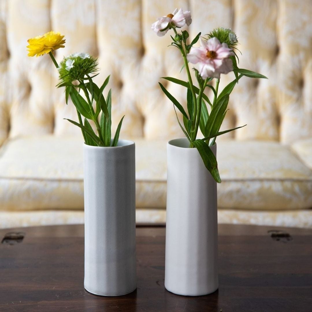 Ember Collective Bloom Vase, handmade white porcelain with a subtle oval rim, 8 inches tall, holding a small floral arrangement