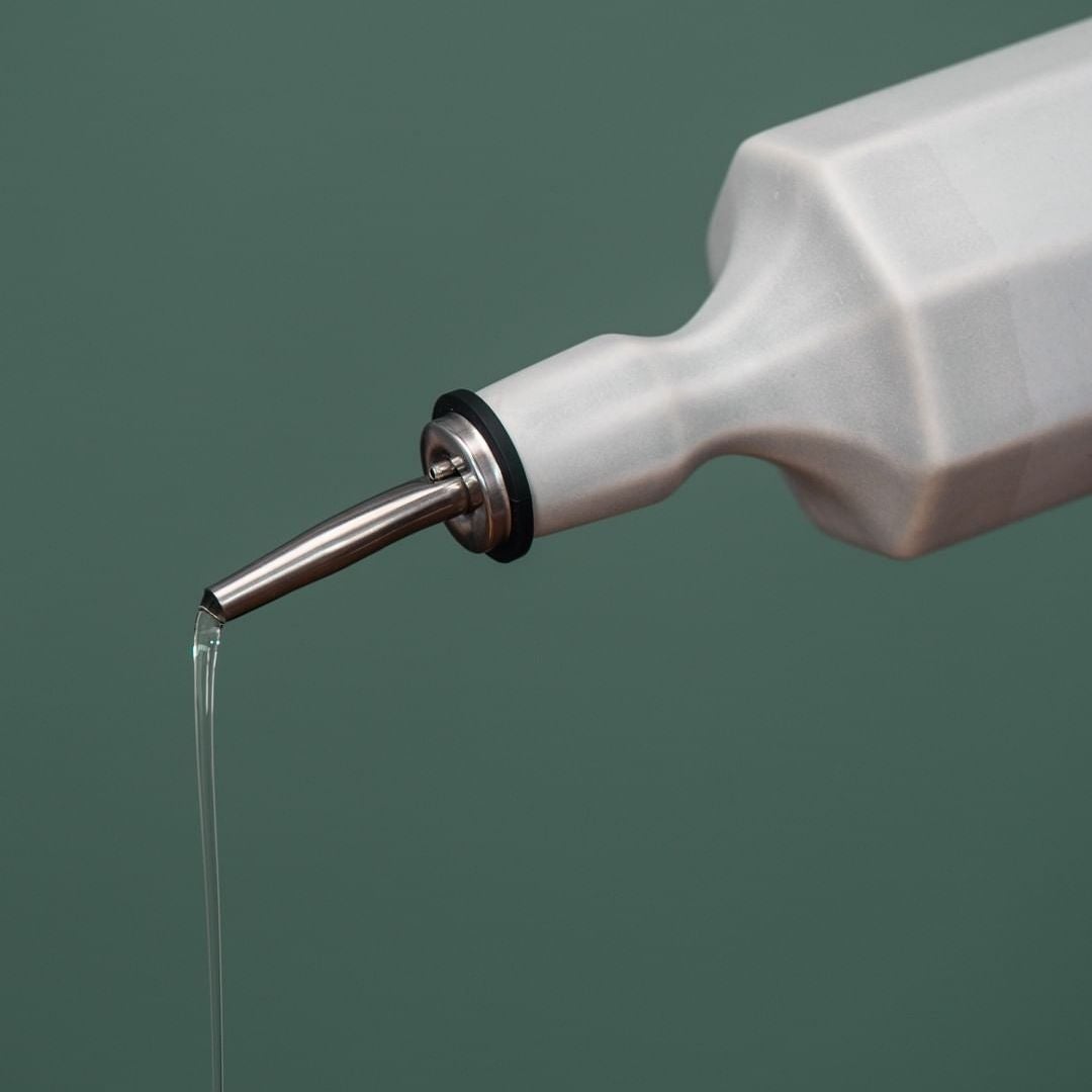 Elixir satin-glazed porcelain olive oil dispenser with drip-free pour spout on a kitchen countertop