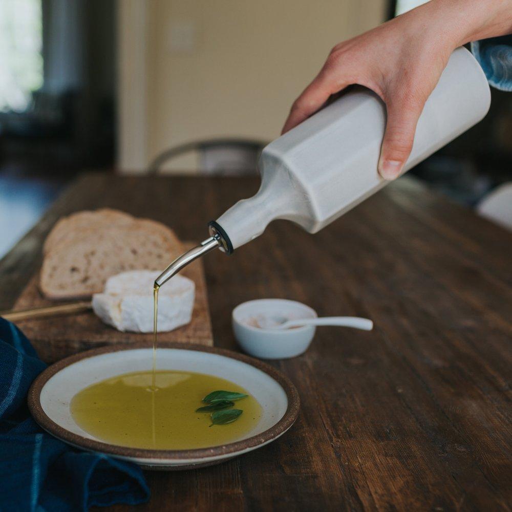 Elixir satin-glazed porcelain olive oil dispenser with drip-free pour spout on a kitchen countertop