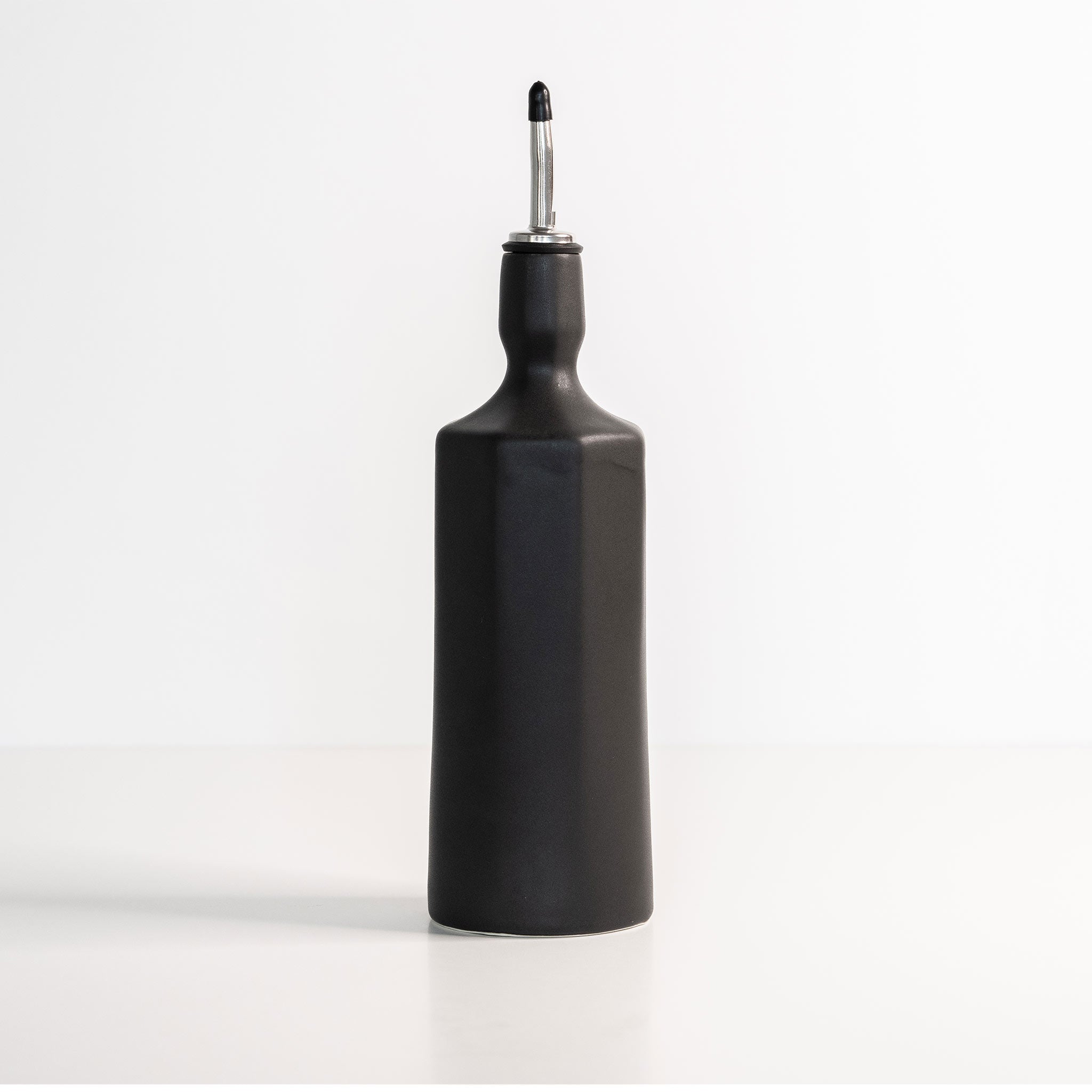 Elixir satin-glazed porcelain olive oil dispenser with drip-free pour spout on a kitchen countertop