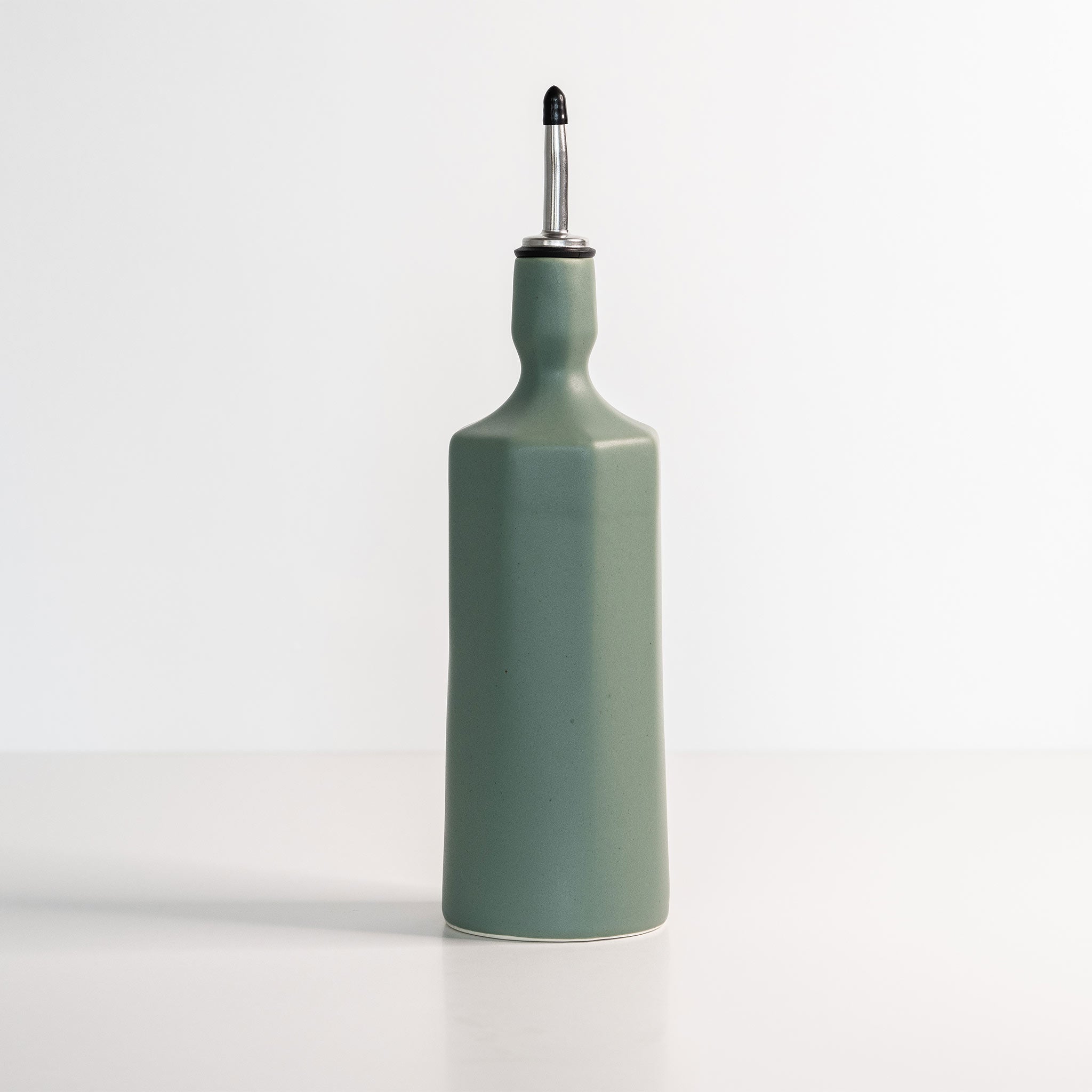 Elixir satin-glazed porcelain olive oil dispenser with drip-free pour spout on a kitchen countertop