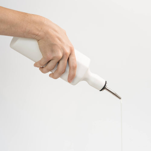 Elixir satin-glazed porcelain olive oil dispenser with drip-free pour spout on a kitchen countertop