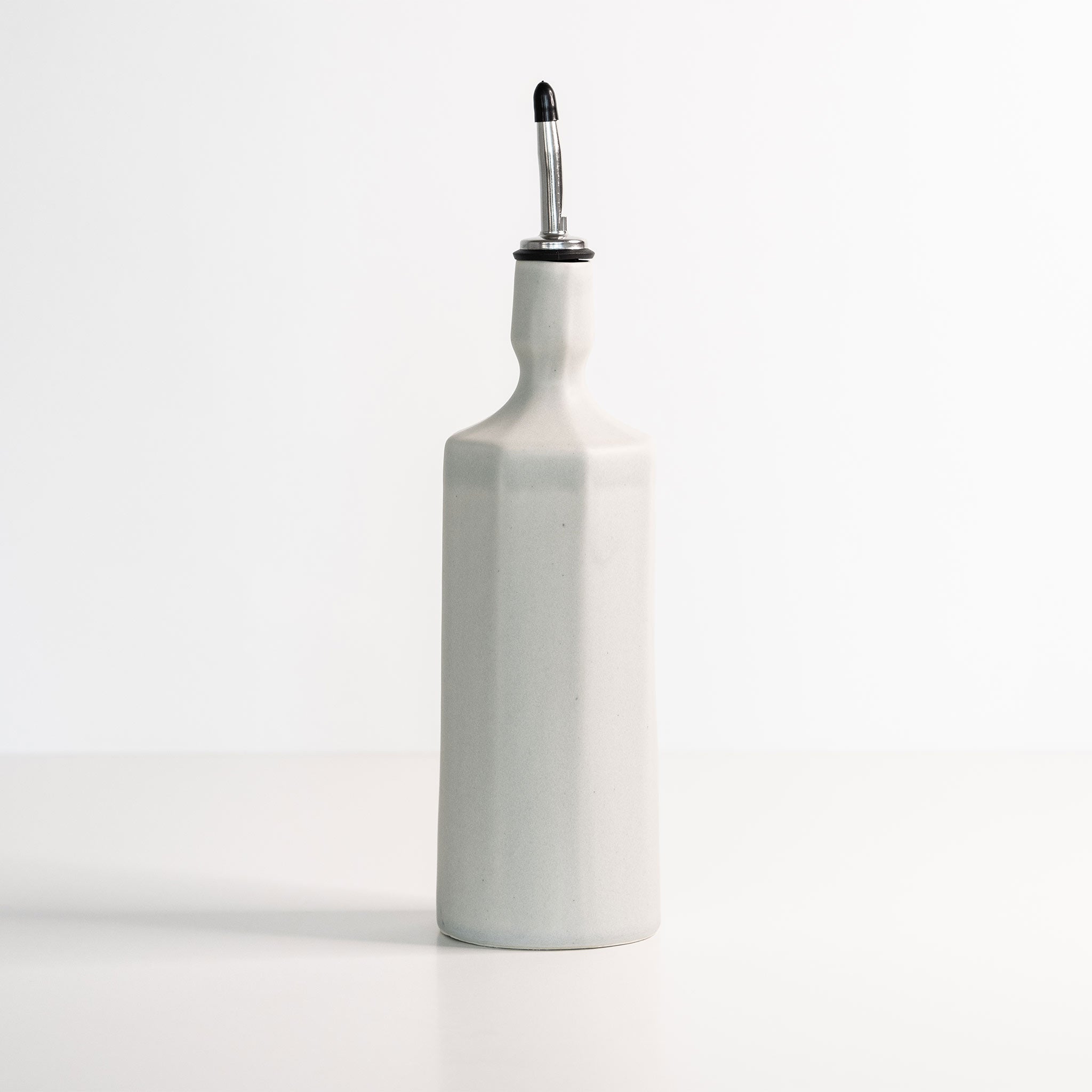 Elixir satin-glazed porcelain olive oil dispenser with drip-free pour spout on a kitchen countertop