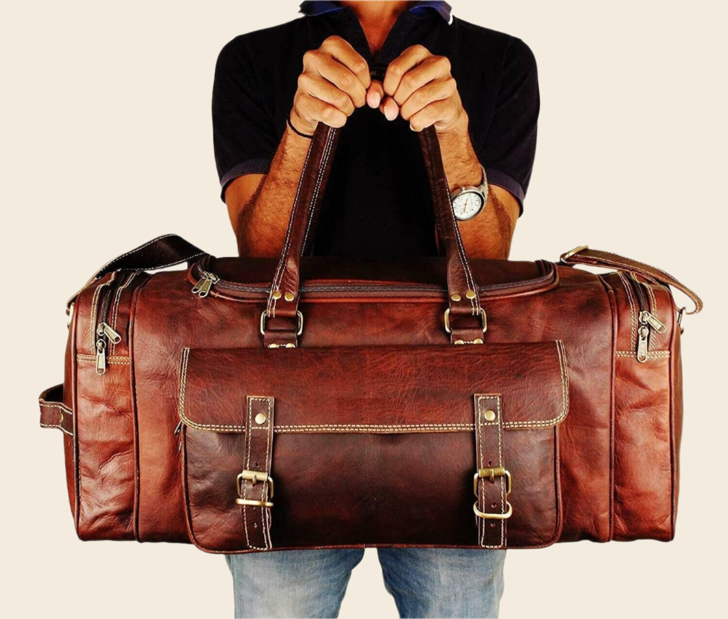 Vintage brown full-grain goat leather weekender duffle bag with brass hardware and matching toiletry bag on neutral background