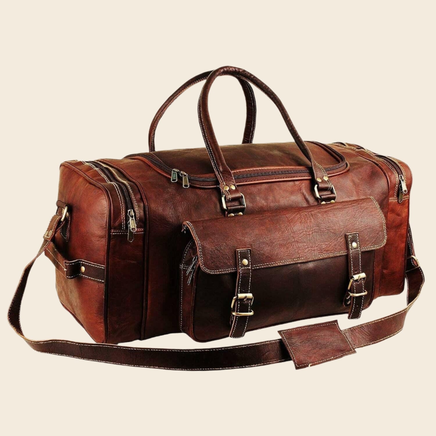 Vintage brown full-grain goat leather weekender duffle bag with brass hardware and matching toiletry bag on neutral background