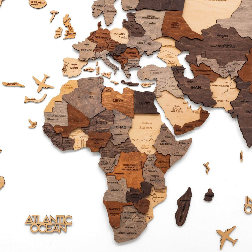 Multicolor 3D layered wooden world map wall art with engraved country names and borders mounted on a neutral wall