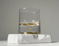Set of two glass tumblers with genuine meteorite fragments suspended in high-clarity bases, shown in Antique Tin and Amber Gold finishes
