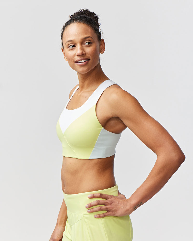 Pionxr color-block sports bra top with flat seam construction and longer cropped length in bold two-tone colorway