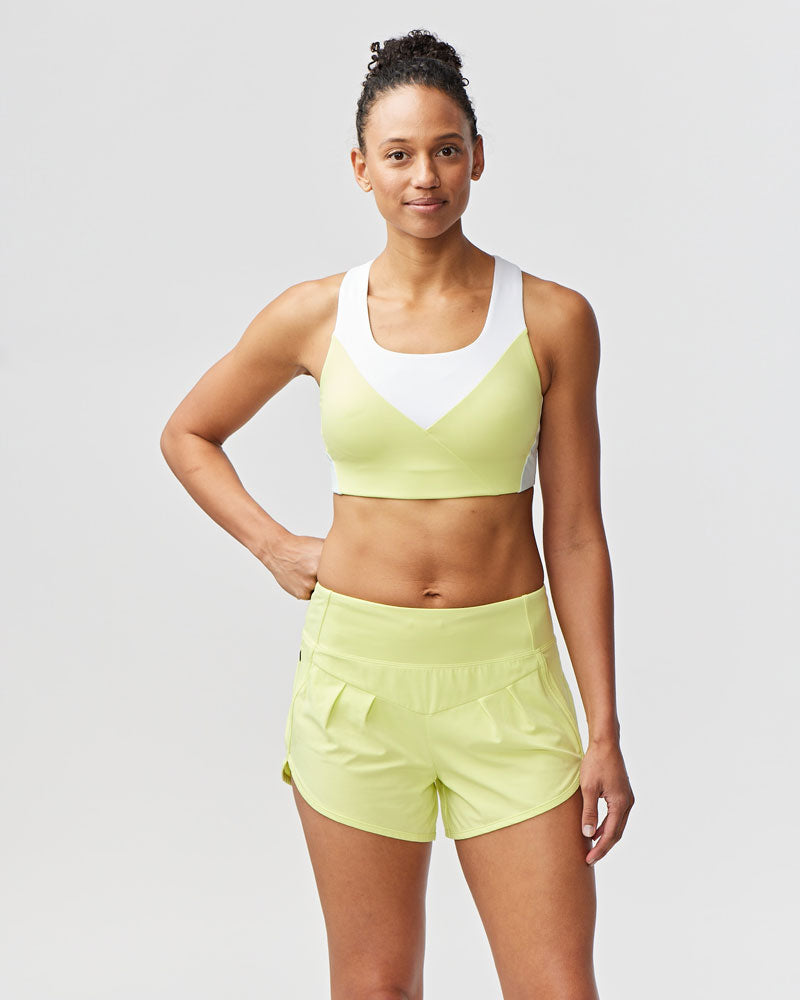 Pionxr color-block sports bra top with flat seam construction and longer cropped length in bold two-tone colorway