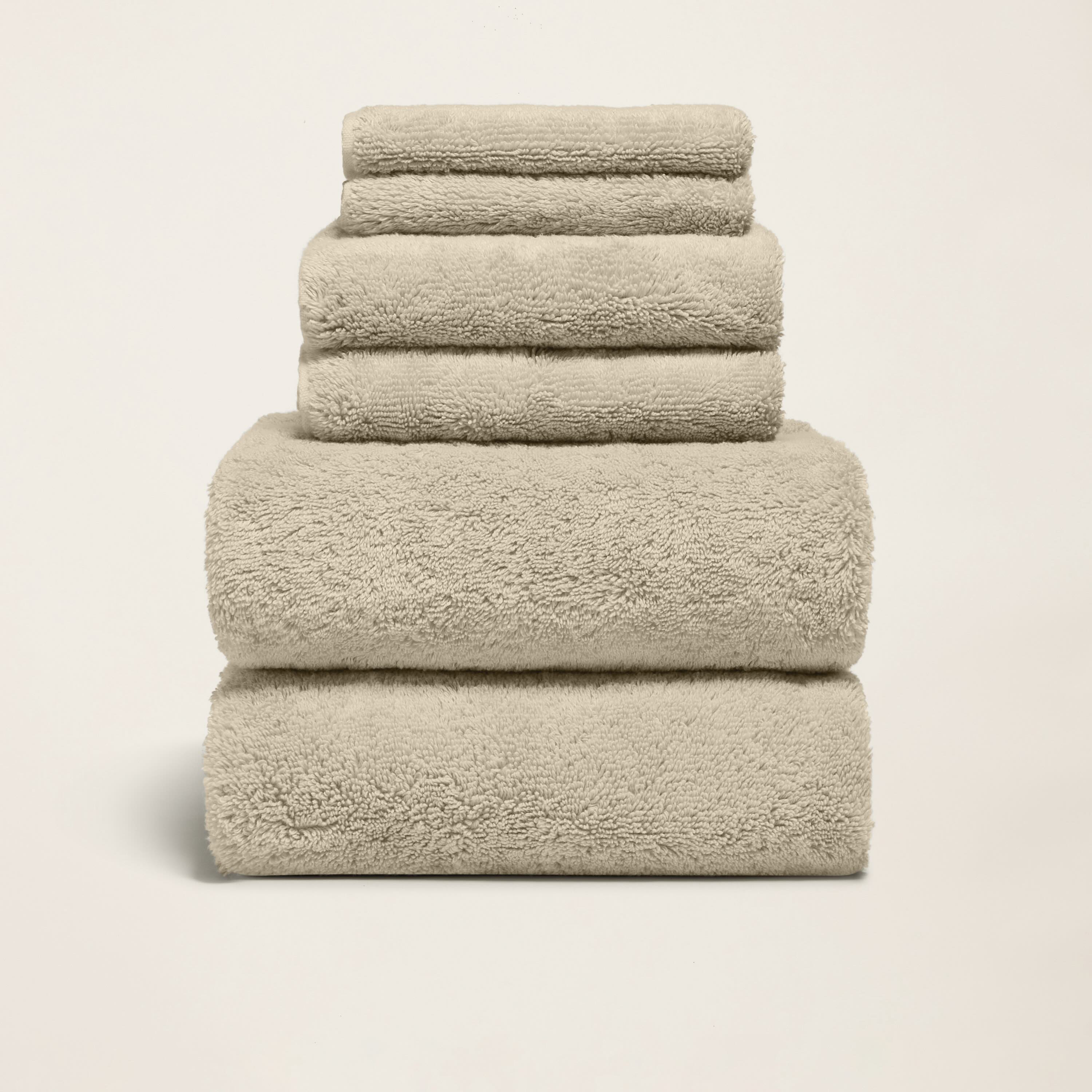 Stack of folded thick white 800 GSM Australian cotton bath towels showing dense plush loop texture