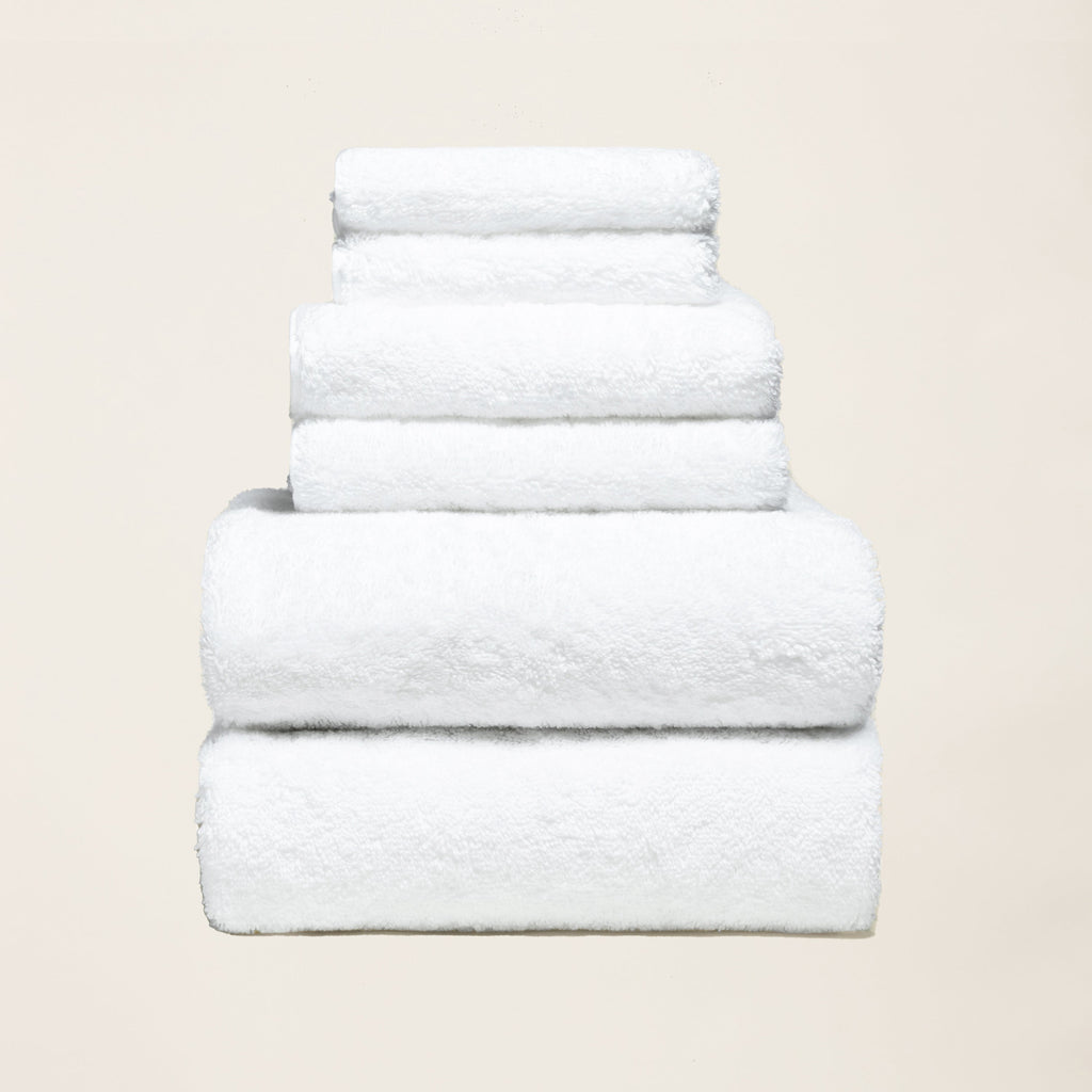 Stack of folded thick white 800 GSM Australian cotton bath towels showing dense plush loop texture