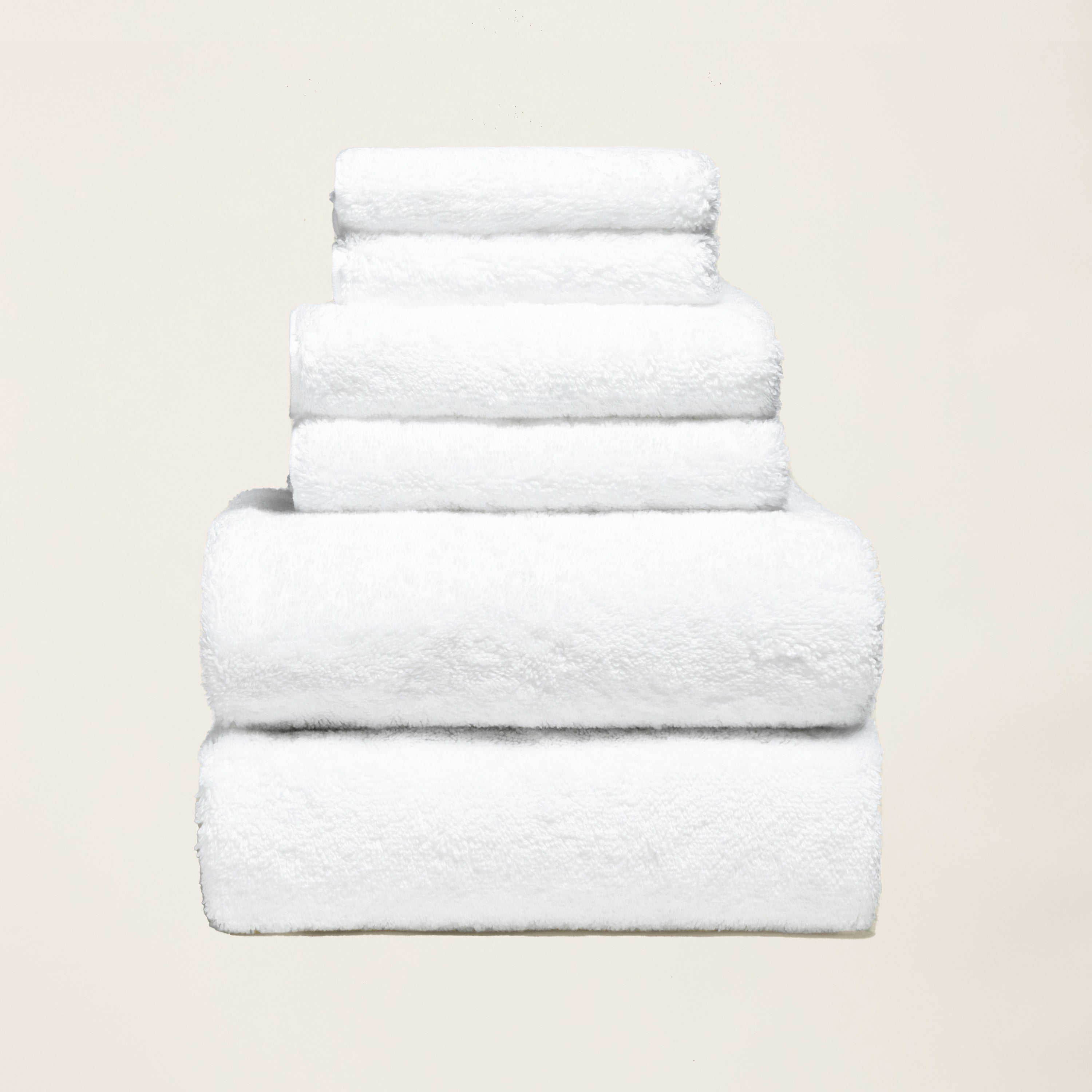 Stack of folded thick white 800 GSM Australian cotton bath towels showing dense plush loop texture