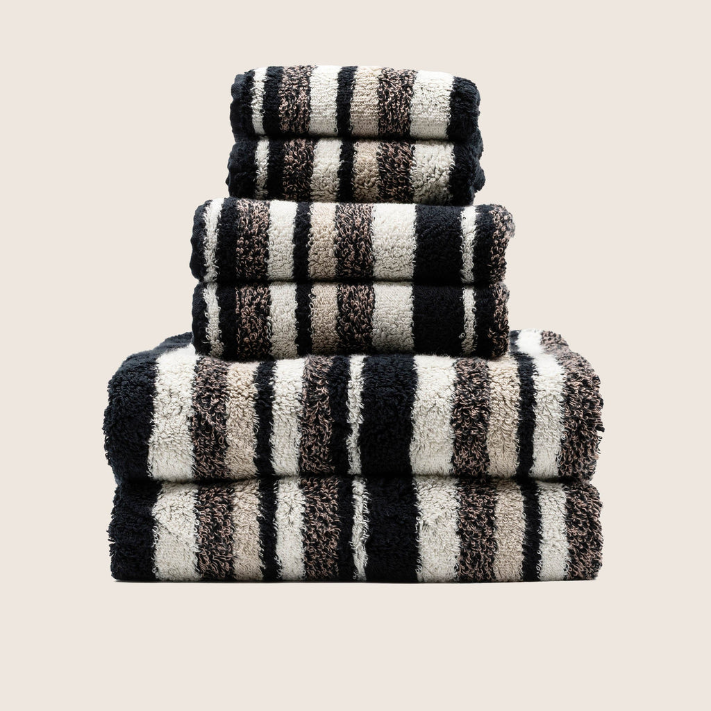 Stack of folded thick white 800 GSM Australian cotton bath towels showing dense plush loop texture