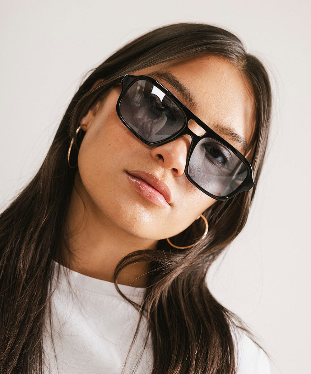 Men's rectangular vintage-inspired aviator sunglasses with light lenses and a gold-tone frame, shown with leather storage case