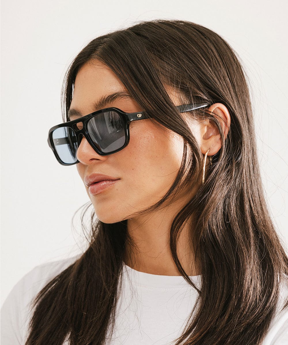 Men's rectangular vintage-inspired aviator sunglasses with light lenses and a gold-tone frame, shown with leather storage case