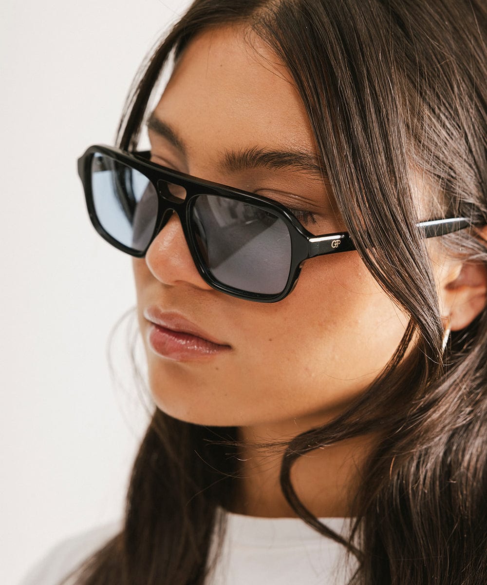 Men's rectangular vintage-inspired aviator sunglasses with light lenses and a gold-tone frame, shown with leather storage case