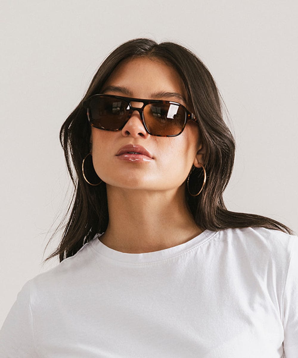 Men's rectangular vintage-inspired aviator sunglasses with light lenses and a gold-tone frame, shown with leather storage case