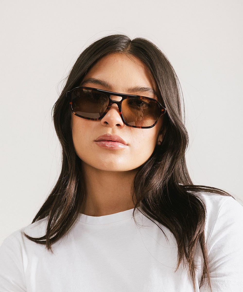 Men's rectangular vintage-inspired aviator sunglasses with light lenses and a gold-tone frame, shown with leather storage case
