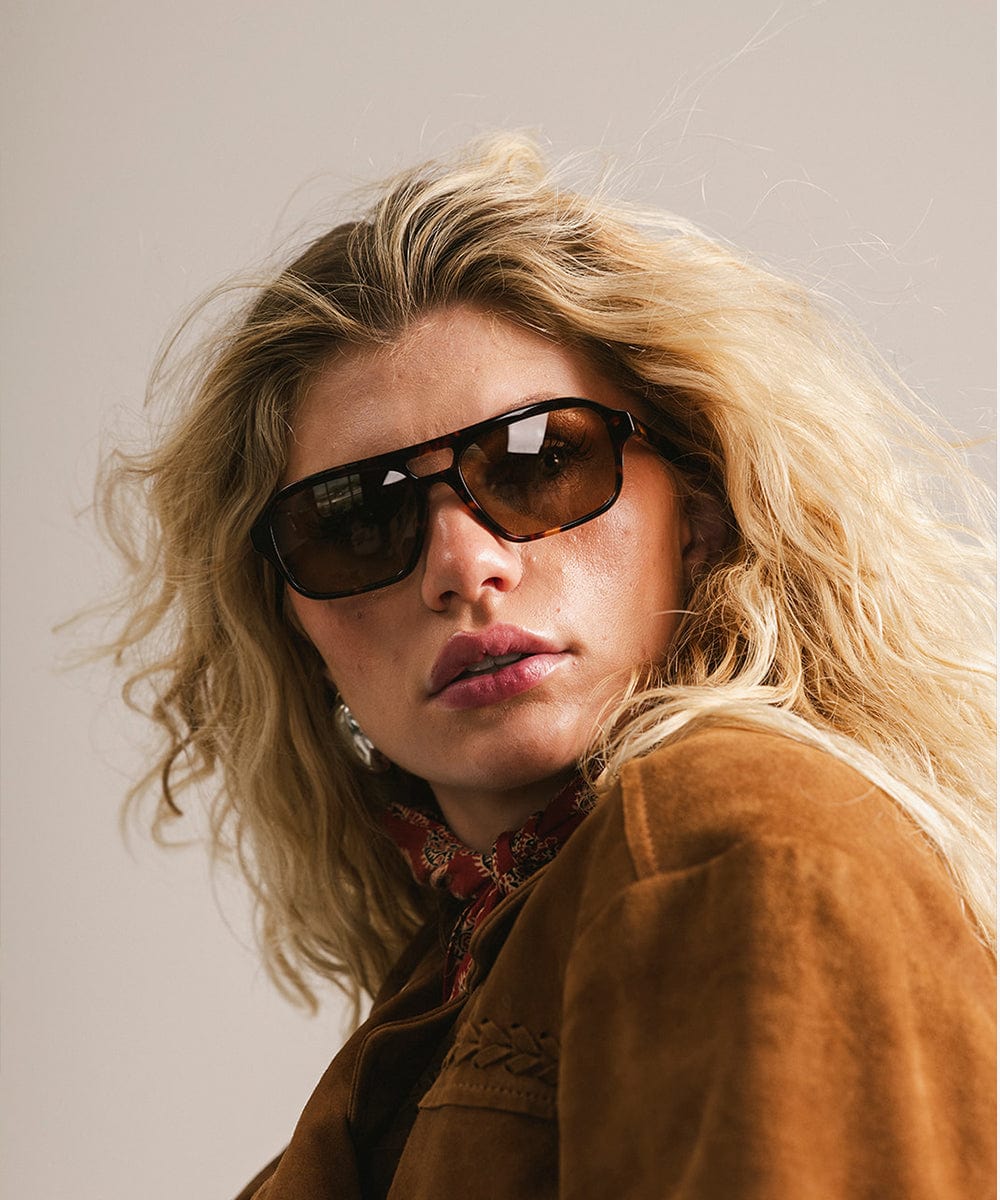 Men's rectangular vintage-inspired aviator sunglasses with light lenses and a gold-tone frame, shown with leather storage case