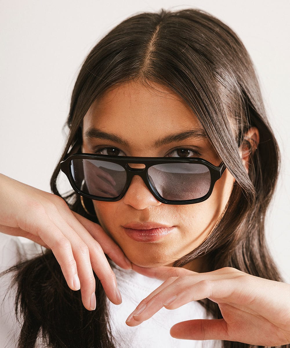 Men's rectangular vintage-inspired aviator sunglasses with light lenses and a gold-tone frame, shown with leather storage case