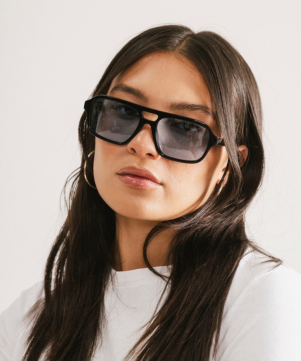 Men's rectangular vintage-inspired aviator sunglasses with light lenses and a gold-tone frame, shown with leather storage case