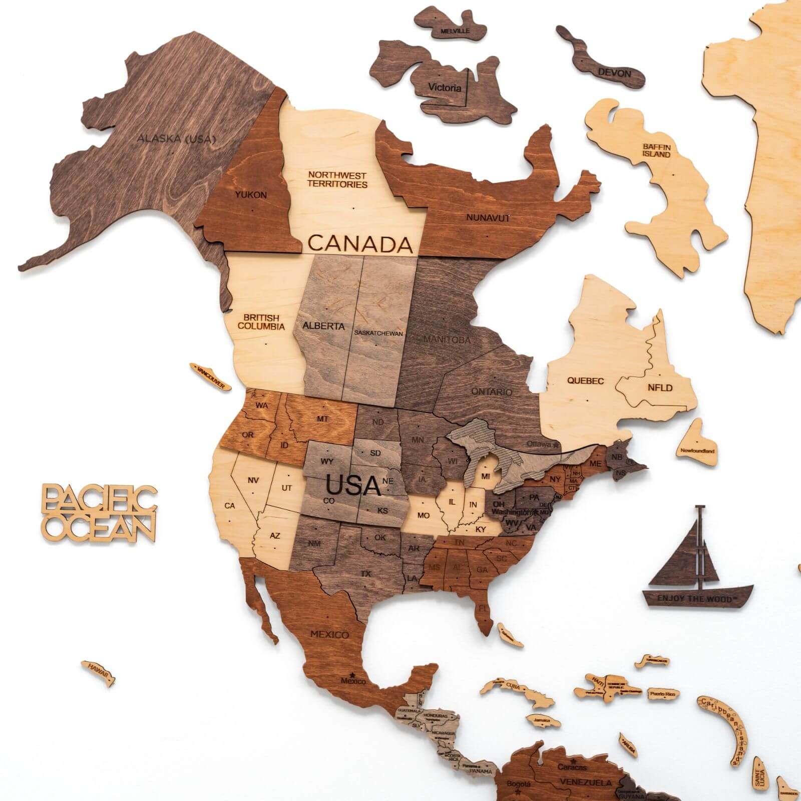 Multicolor 3D layered wooden world map wall art with engraved country names and borders mounted on a neutral wall
