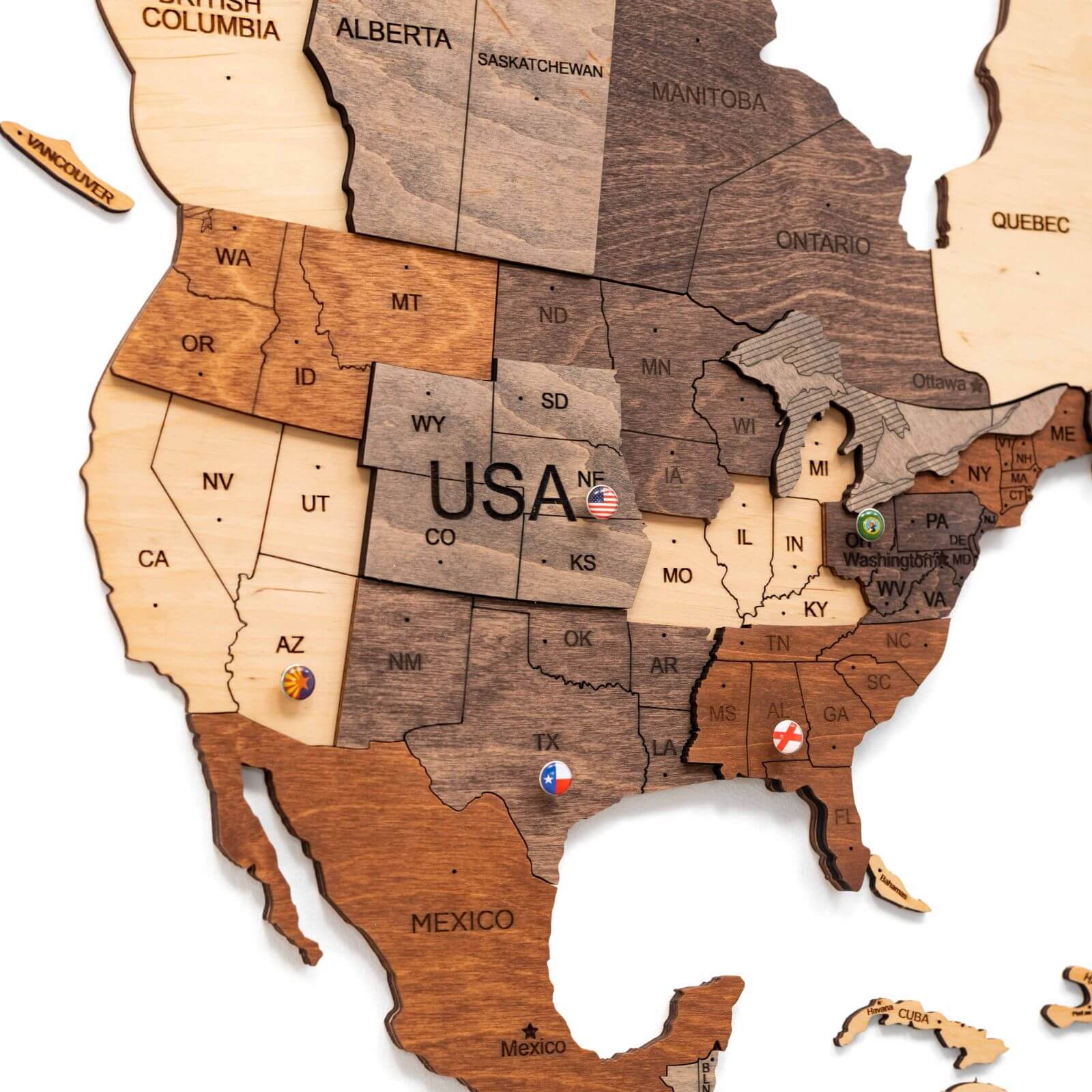 Multicolor 3D layered wooden world map wall art with engraved country names and borders mounted on a neutral wall